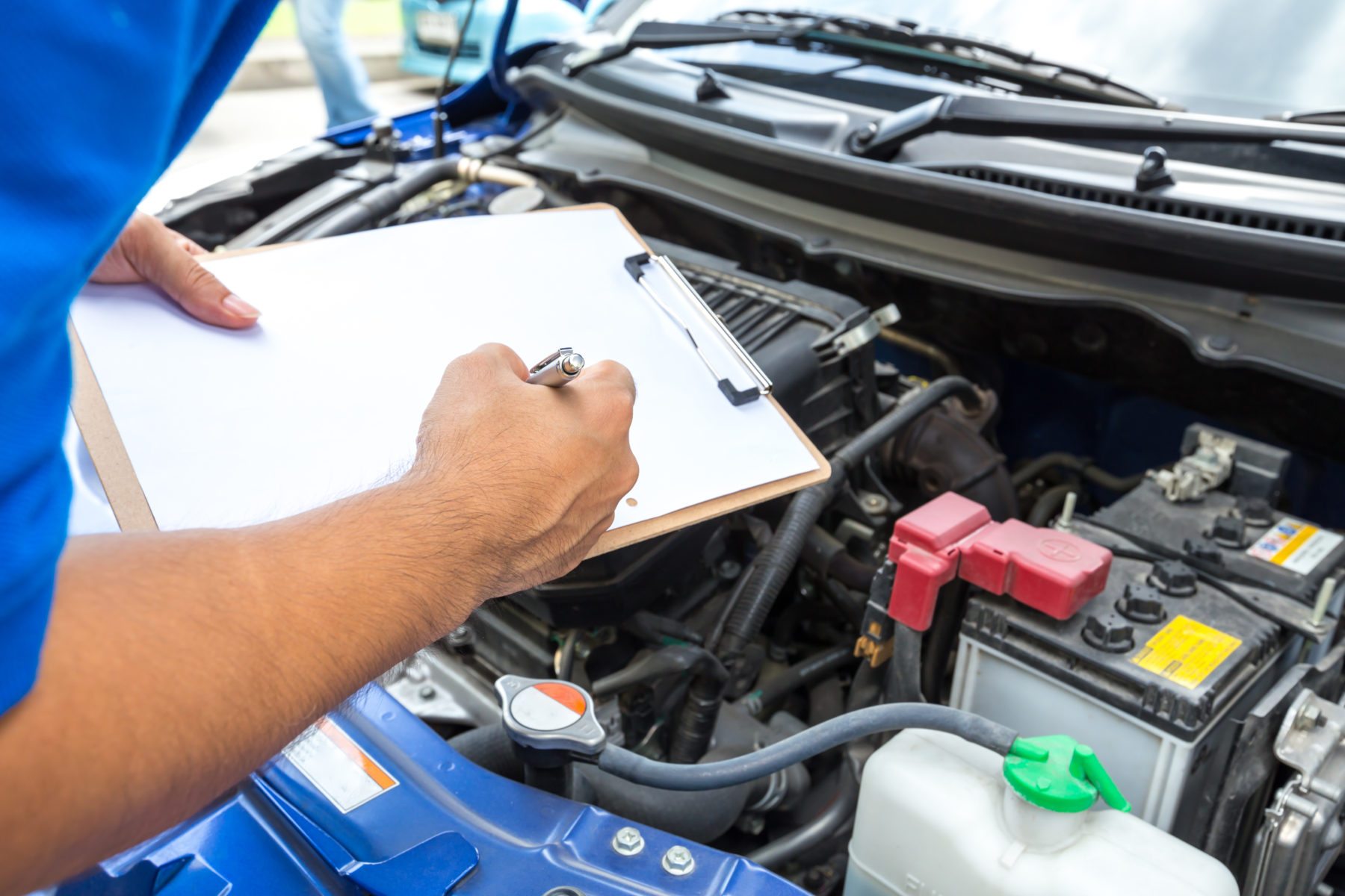 Mechanic man holding clipboard and check the car